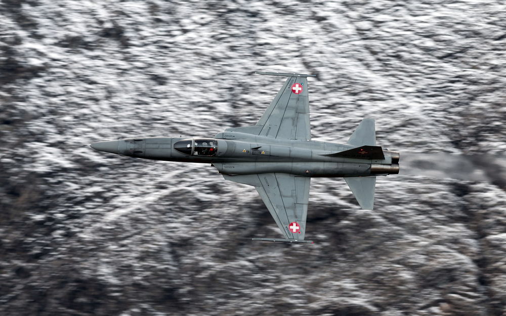 Обои для рабочего стола Военный самолет F - 5 E летит над поверхностью воды