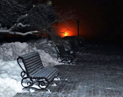 Обои на рабочий стол Скамейки, стоящие на аллее зимнего парка с ярко горящим красным фонарем на фоне ночного неба, автор Вадим Корнеев