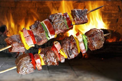 Обои на рабочий стол Шашлыки на фоне горящих поленьев в камине
