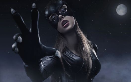 Обои на рабочий стол Catwoman, женщина-кошка выставила вперед руку в перчатке с когтями на фоне ночного неба с полной Луной