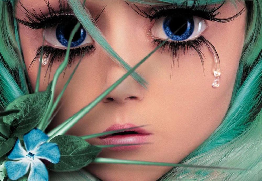 Обои для рабочего стола Девочка с синими глазами, с которых капают слезы с зелеными волосами, с голубым цветком и зелеными листьями у лица
