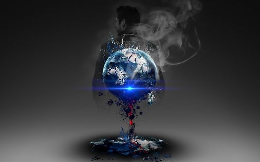 Обои на рабочий стол У мужчины за спиной рассыпается земной шар с выделением дыма
