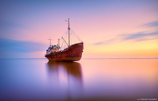 Обои на рабочий стол Старый, заброшенный корабль, севший на мель в морском заливе на фоне вечернего небосклона с сиреневыми облаками, автор Lyokin