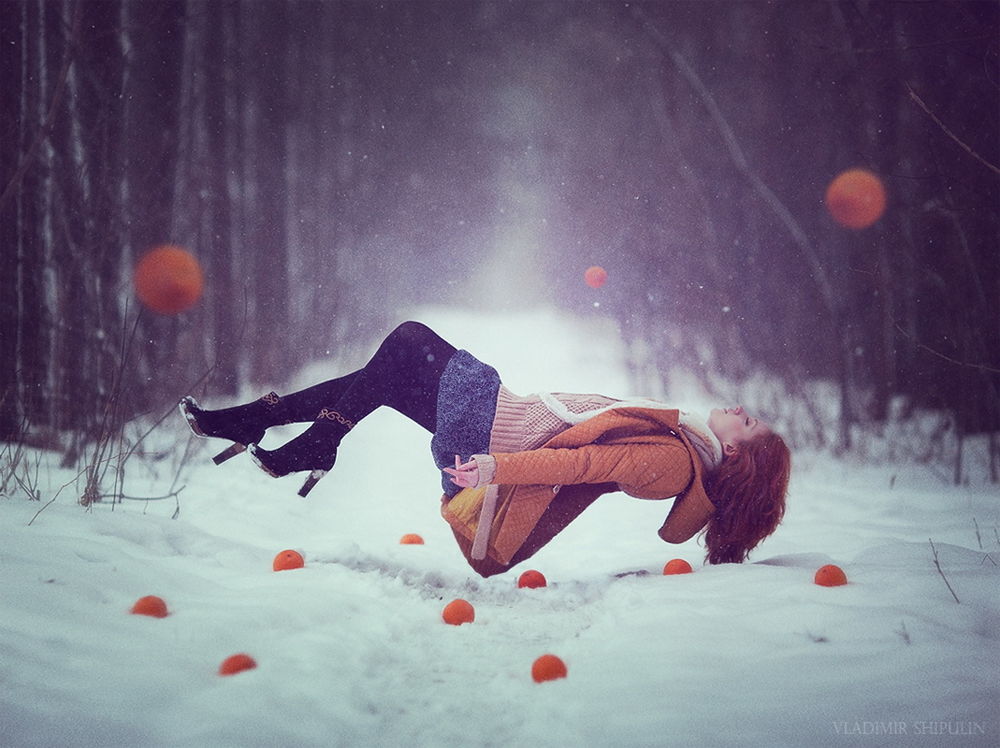 Обои для рабочего стола Спящая, рыжеволосая девушка, парящая над заснеженной тропинкой в лесной роще с лежащими на снегу ярко-оранжевыми апельсинами, автор Vladim_Shipulin