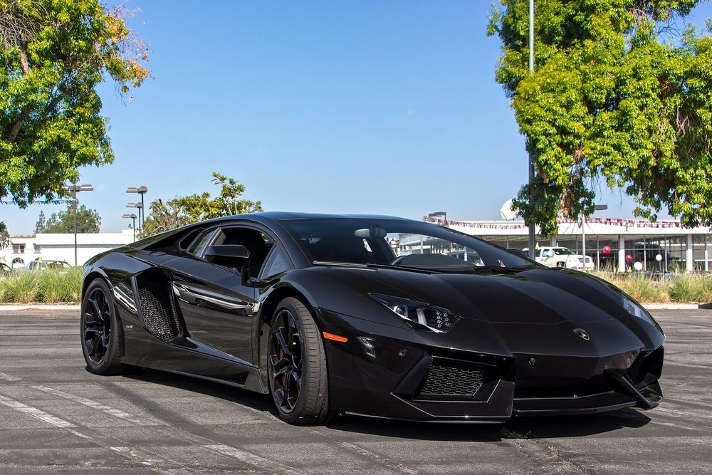 Обои для рабочего стола Черный Lamborghini Aventador LP700-4 стоит на асфальте