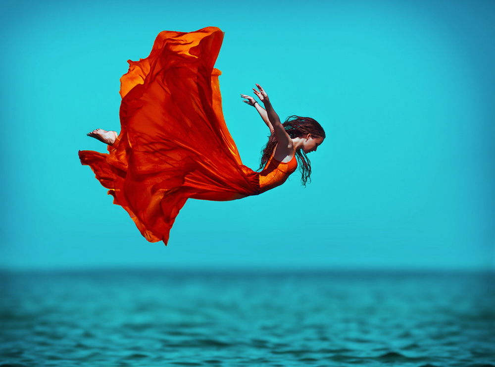 Обои для рабочего стола Темноволосая женщина в пышном, красном платье, парящая над поверхностью моря, автор Светлана Беляева