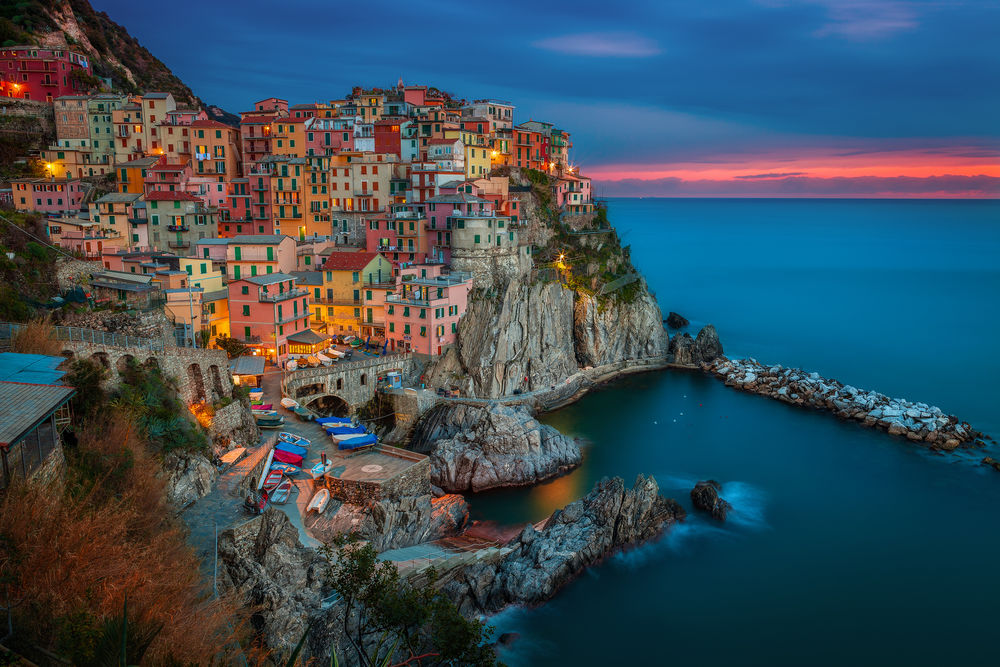 Обои для рабочего стола Цветной город на скале Манарола, Италия / Manarola, Italy, на фоне заката на вечернем небосклоне