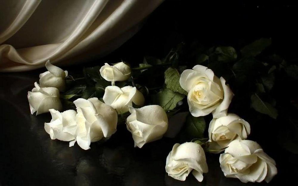 Обои для рабочего стола Букет белых роз в капельках росы, лежит на черном столе