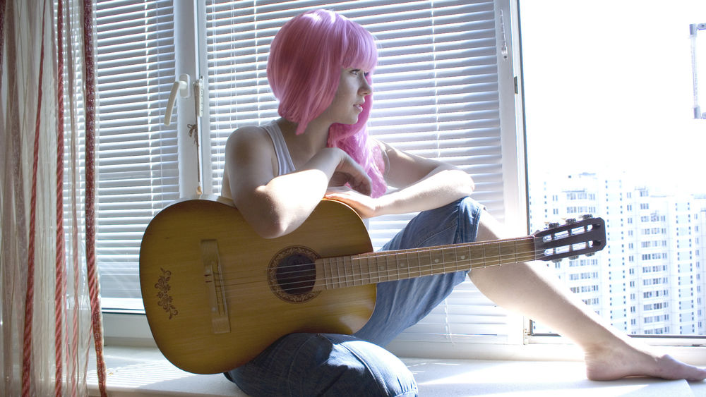 Обои для рабочего стола Девушка с розовыми волосами сидит на подоконике и держит на руках гитару