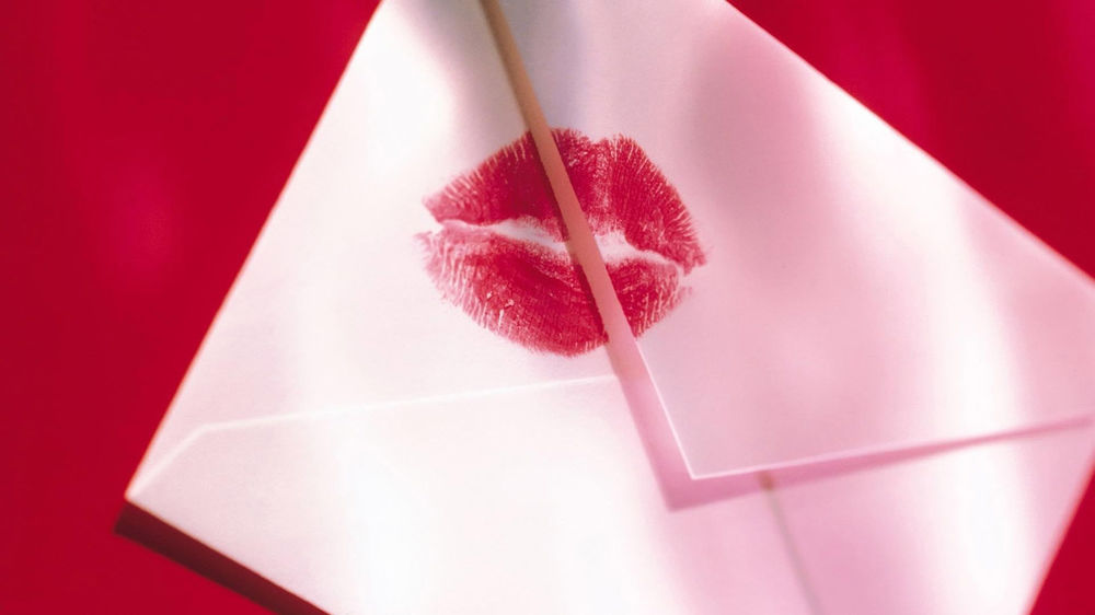 Обои для рабочего стола Белый конверт с отпечатком помады женский губ в виде поцелуя на красном фоне