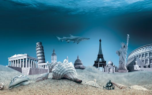 Обои на рабочий стол На песчаном морском дне находятся морские раковины, мировые достопримечательности (Эйфелева башня, Американская Статуя Свободы, башня Биг-Бен, гробницы и статуи скифов и другие), над ними проплывает акула