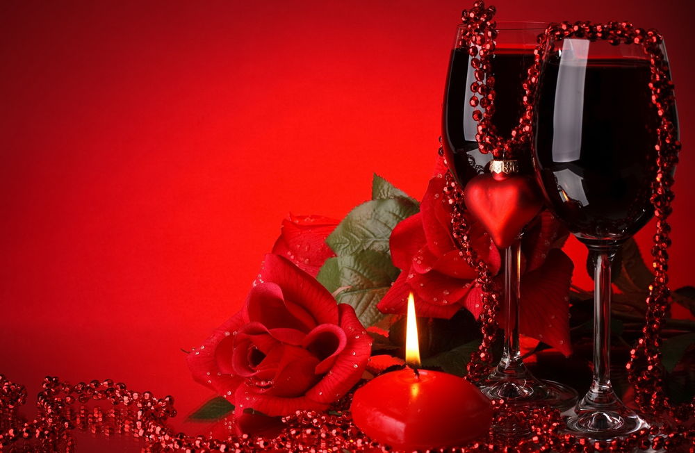Обои для рабочего стола На красном фоне, два фужера с вином, красные розы, бусы, сердечки и свеча