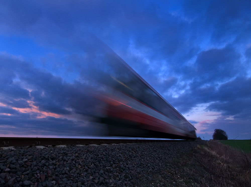 Обои для рабочего стола Пассажирский поезд, мчавшийся на огромной скорости на фоне вечернего, пасмурного небосклона, автор Mirek Grobelski