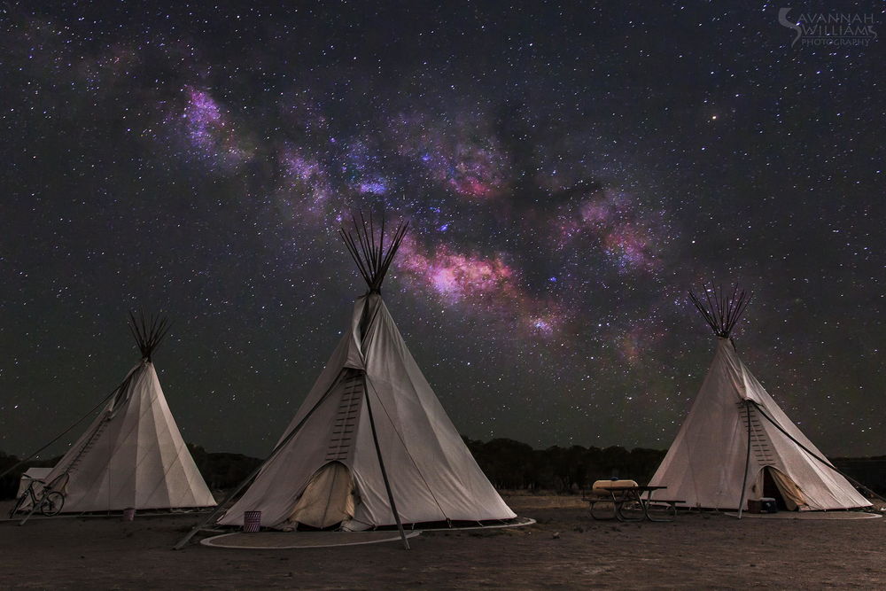 Обои для рабочего стола Индейские жилища вигвами, стоящие в предгорье на фоне ночного, звездного неба и красивого Млечного пути