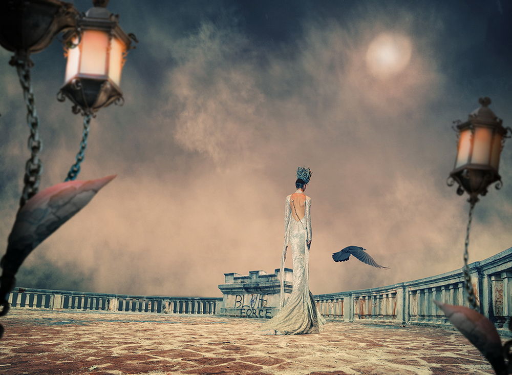 Обои для рабочего стола Стройная женщина в длинном, белом платье, стоящая на смотровой площадке, огороженной каменным забором, горящими уличными фонарями на фоне небосклона с солнечным диском, затянутом туманной дымкой, парящей в воздухе черной вороной, автор Garas Ionut