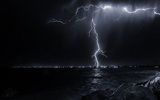 Обои на рабочий стол Яркие разряды молний в ночном, грозовом небе над морским побережьем