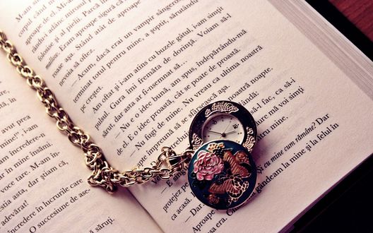 Обои на рабочий стол Часы на цепочке лежат на странице открытой книги