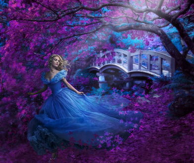 Обои на рабочий стол Актриса Лили Джеймс / Lily James в легком, воздушном, синем платье, стоящая под деревом с сиреневыми листьями на берегу водоема с проложенным через него пешеходным мостиком, автор Nataliorion