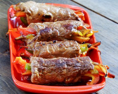Обои на рабочий стол Мясные рулеты фаршированные овощами: морковка, перец, помидоры, в керамической форме для запекания стоят на столе