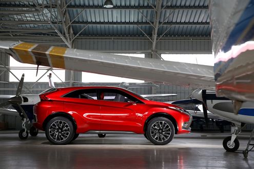 Обои на рабочий стол Автомобиль модели Mitsubishi Concept XR-PHEV II стоит в ангаре для частных самолетов