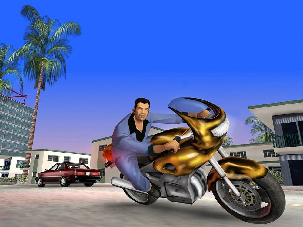 Обои для рабочего стола Томми из игры GTA Vice City мчится по улице города на мотоцикле