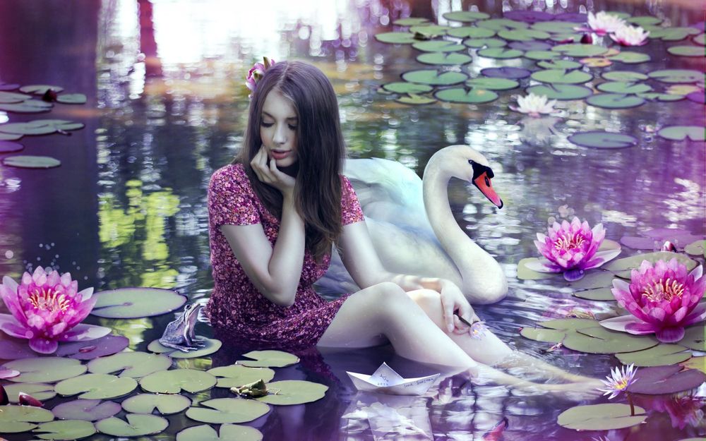 Обои для рабочего стола Девушка сидит в пруду возле цветущих лилий, около нее белый лебедь, лягушка и бумажный кораблик