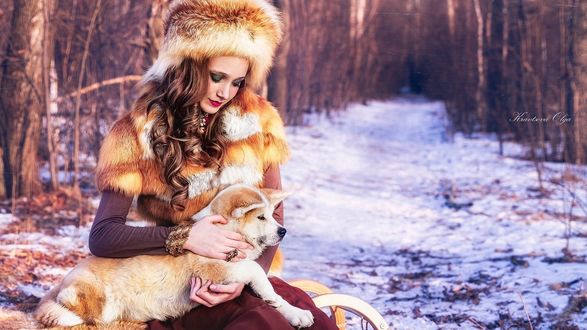 Обои на рабочий стол Русская красавица в меховых одеждах сидит на лесной просеке и держит на руках рыжего пса, Kravslova Olga