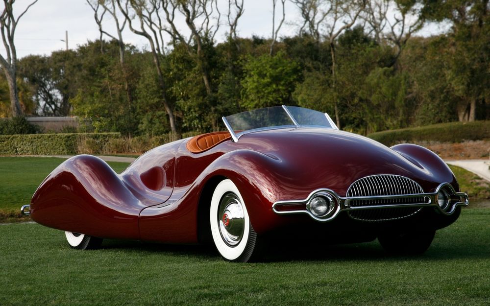 Обои для рабочего стола Автомобиль цвета бардо buick streamliner 1949 retro cars стоит на лужайке, покрытой травой, на заднем плане парк, деревья, кустарник