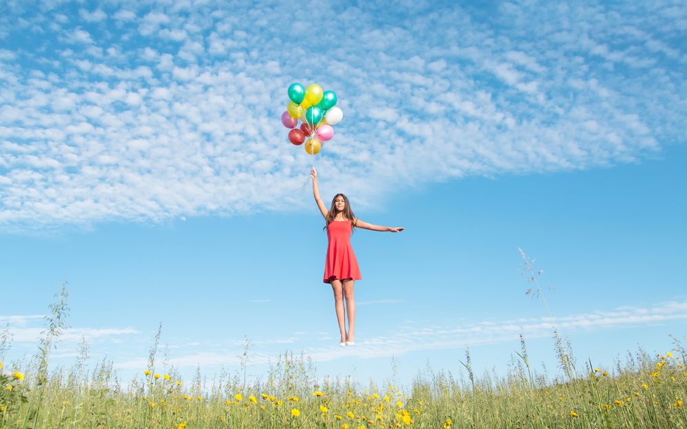 Обои для рабочего стола Девушка летящая в небо на воздушных шариках