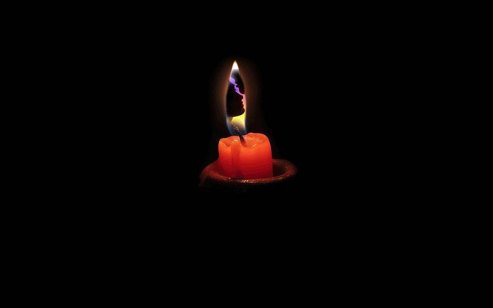 Обои для рабочего стола На черном фоне в подсвечнике горит красная свеча, в языке пламени которой видны силуэты влюбленных мужчины и женщины