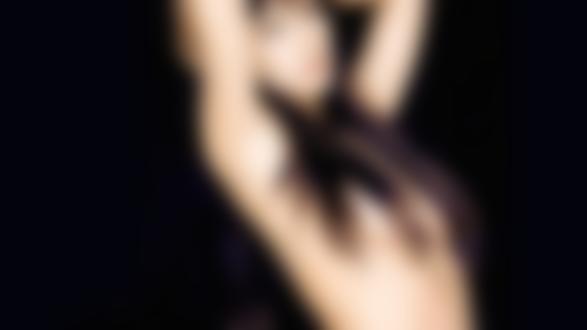 Обои на рабочий стол Полуобнаженная фотомодель Monica Bellucci на черном фоне