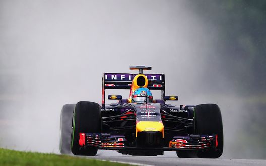 Обои на рабочий стол Гоночный болид F1 на скоростной трассе в дождь