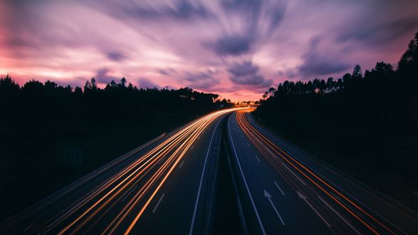 Обои на рабочий стол Автобан с огнями от авто в лесу