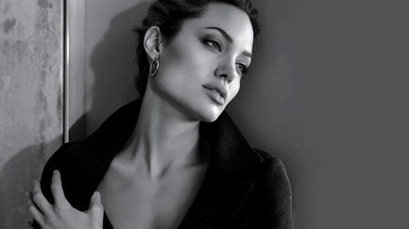 Обои на рабочий стол Angelina Jolie стоит в черном пальто склонив голову