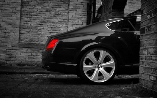 Обои на рабочий стол Задняя часть черного Bentley Continental GT-S выглядывает из-за стены дома