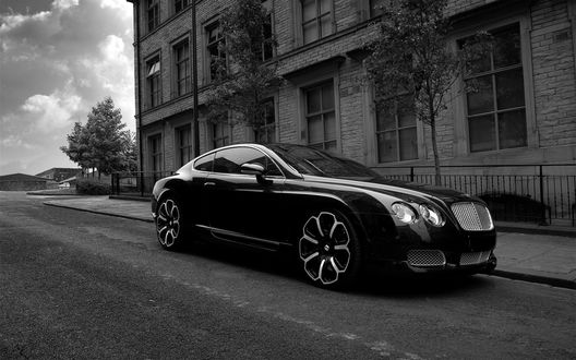 Обои на рабочий стол Черный Bentley GTS стоит на дороге возле дома