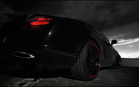 Обои на рабочий стол Корма черного Bentley GTS на фоне неба с тучами