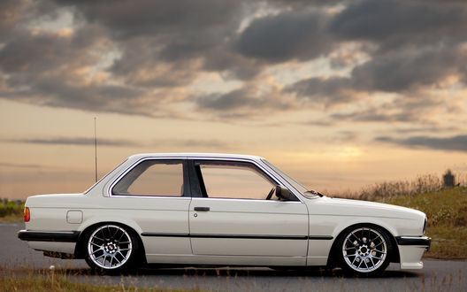 Обои на рабочий стол Белый bmw e30 325i на дороге на фоне неба с облаками