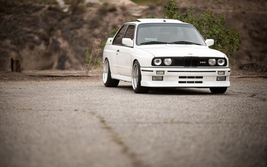 Обои на рабочий стол Белый bmw e30 325i стоит на площадке