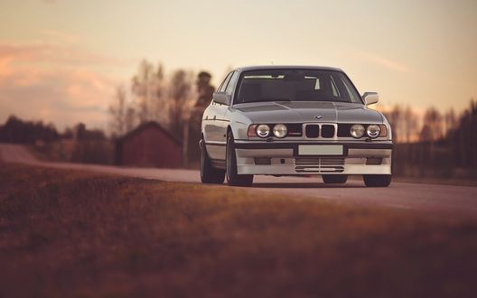 Обои на рабочий стол Серый bmw e34 m5 Аlpina b10 стоит на дороге, на фоне деревьев