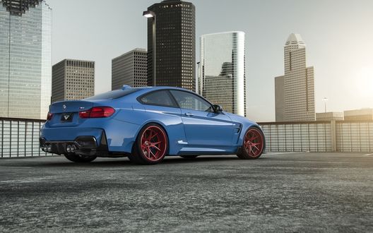Обои на рабочий стол Синий bmw gtrs4 стоит на площадке на фоне высотных домов