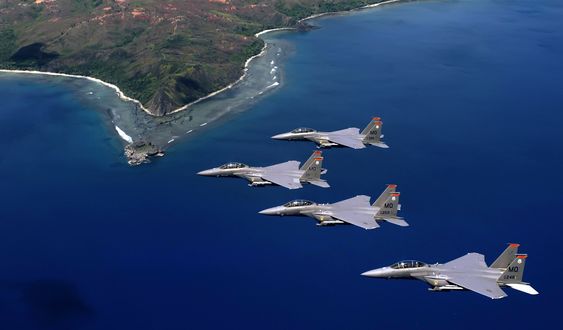 Обои на рабочий стол Истребители-бомбардировщики F-15 летят над островом