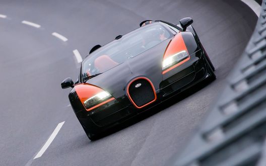 Обои на рабочий стол Черный bugatti veyron едет по трассе