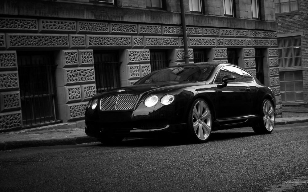 Обои для рабочего стола Черный Bentley GTS стоит возле здания с окнами