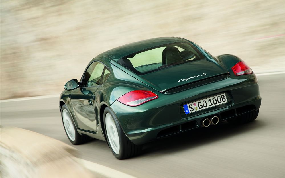 Обои для рабочего стола Автомобиль Porsche Cayman S едет по дороге