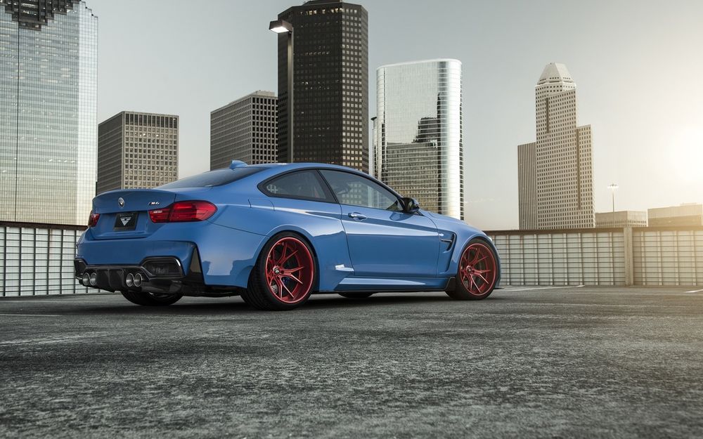Обои для рабочего стола Синий bmw gtrs4 стоит на площадке на фоне высотных домов