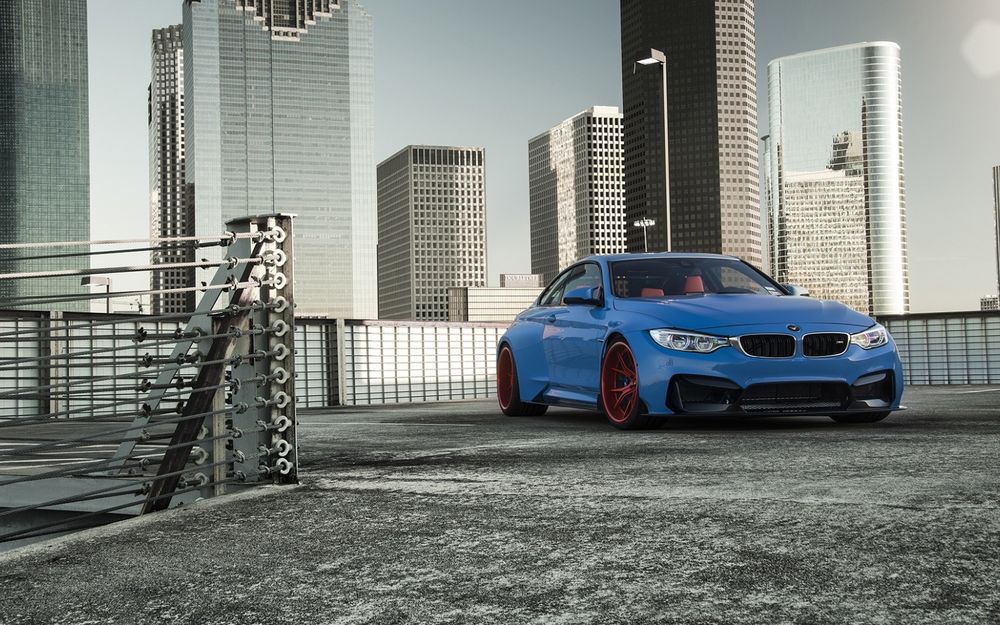 Обои для рабочего стола Синий bmw gtrs4 стоит на фоне высоток (вид спереди)