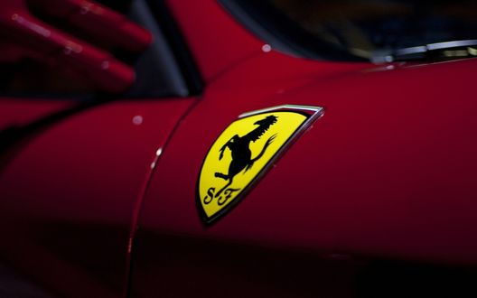 Обои на рабочий стол Шильдик Ferrari на крыле авто