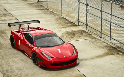 Обои на рабочий стол Ferrari на площадке возле ограждения