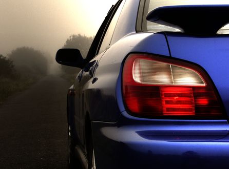 Обои на рабочий стол Subaru на дороге на фоне деревьев в тумане